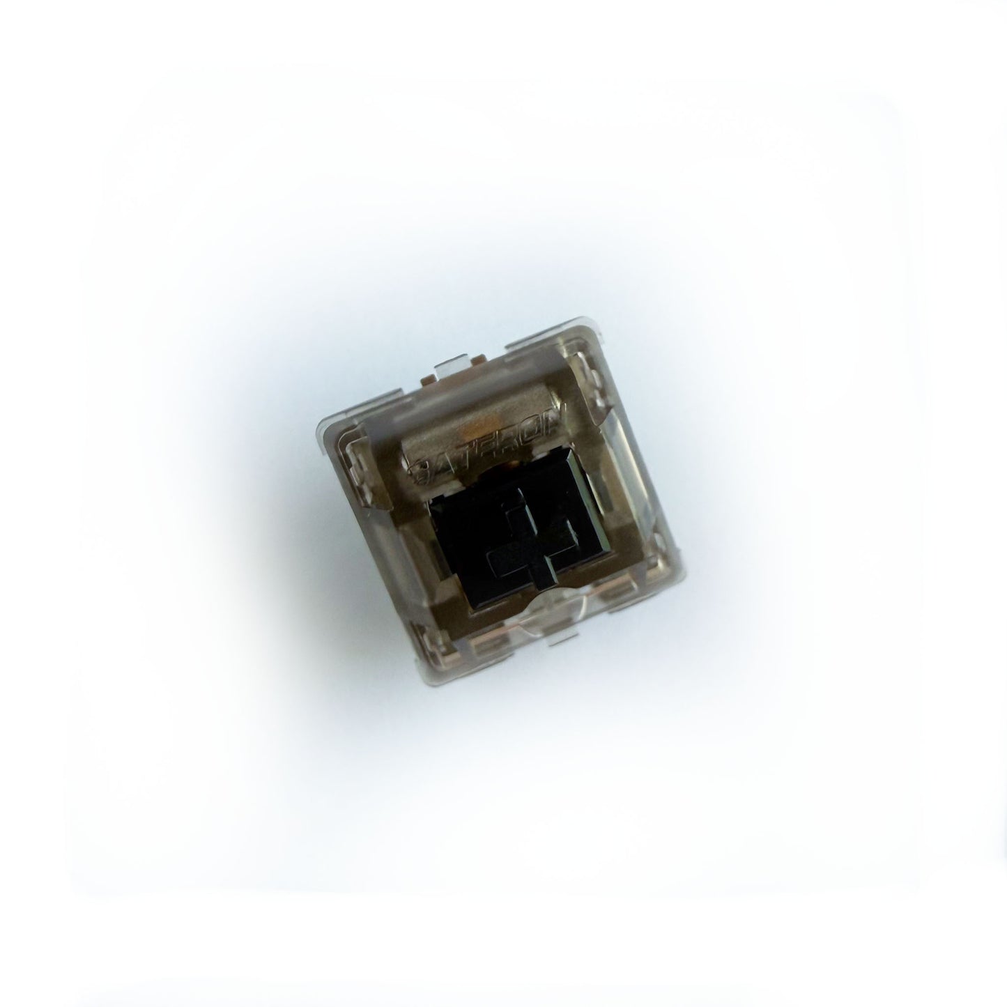 A linear keyboard switch on a white background. The switch component is black, and the casing is a translucent black with the word "GATERON" imprinted into it.