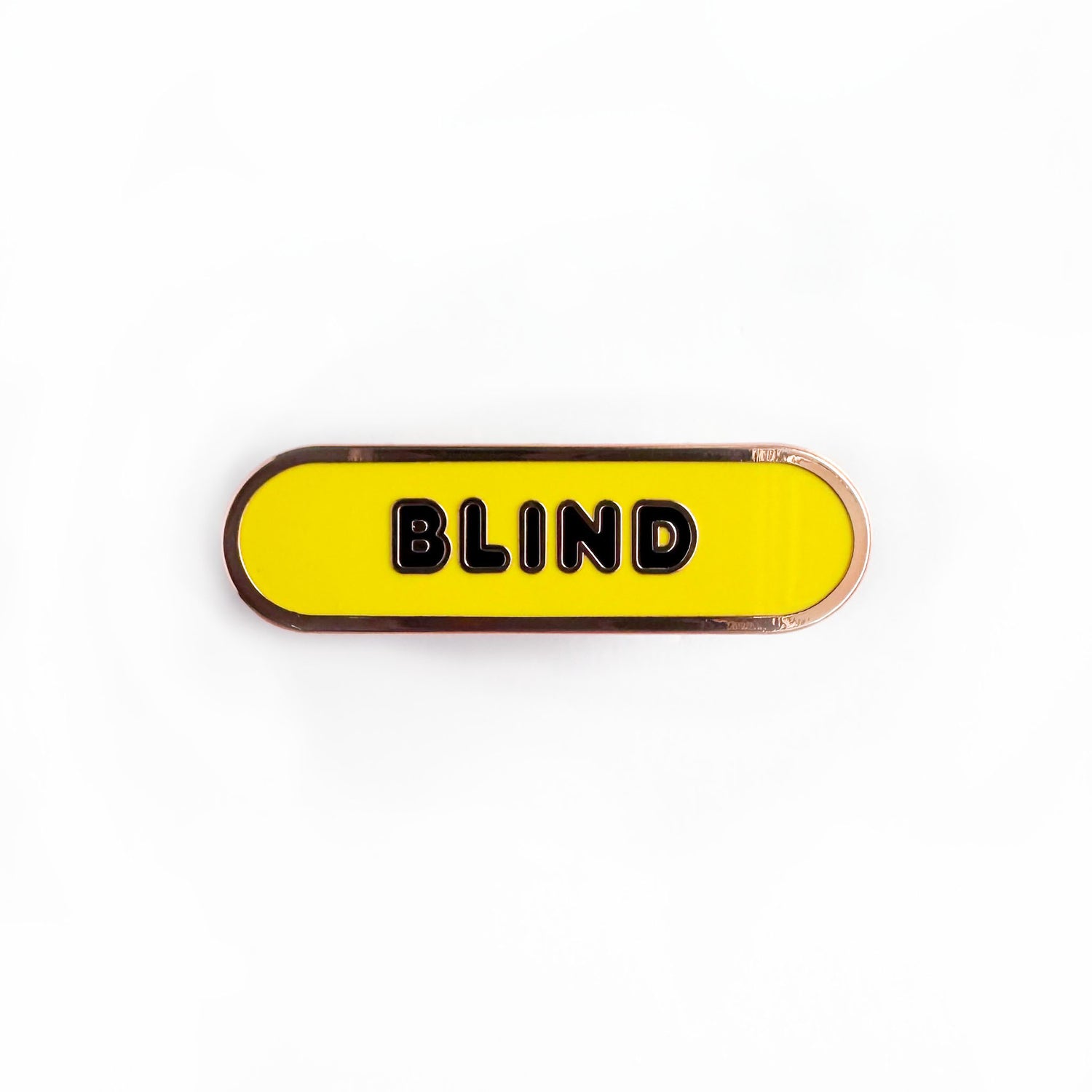 Oval shaped enamel pin with "blind" written in black text on a yellow background.