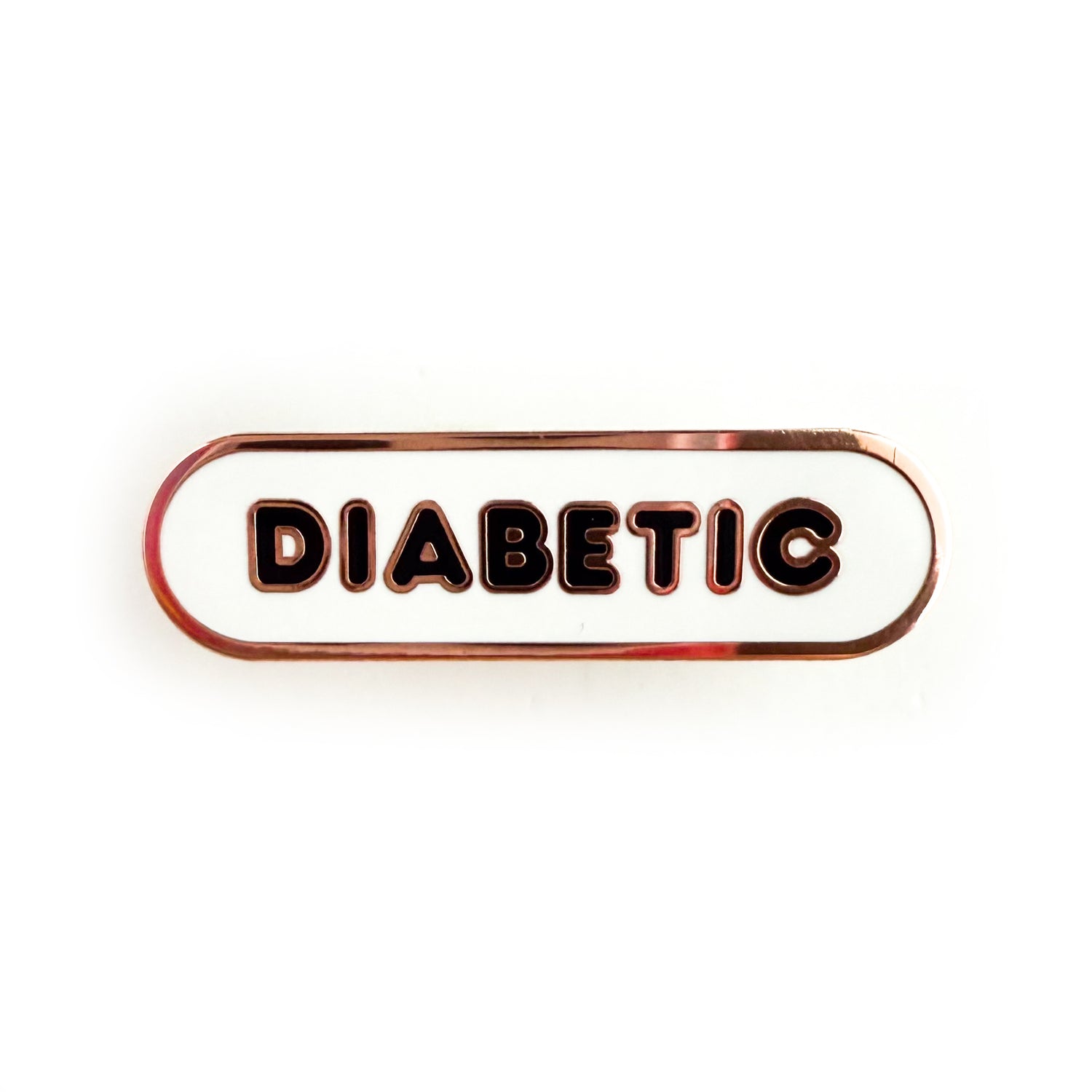 A bandaid shaped pin with the text DIABETIC in bubble letters. The background is white and the text is black.