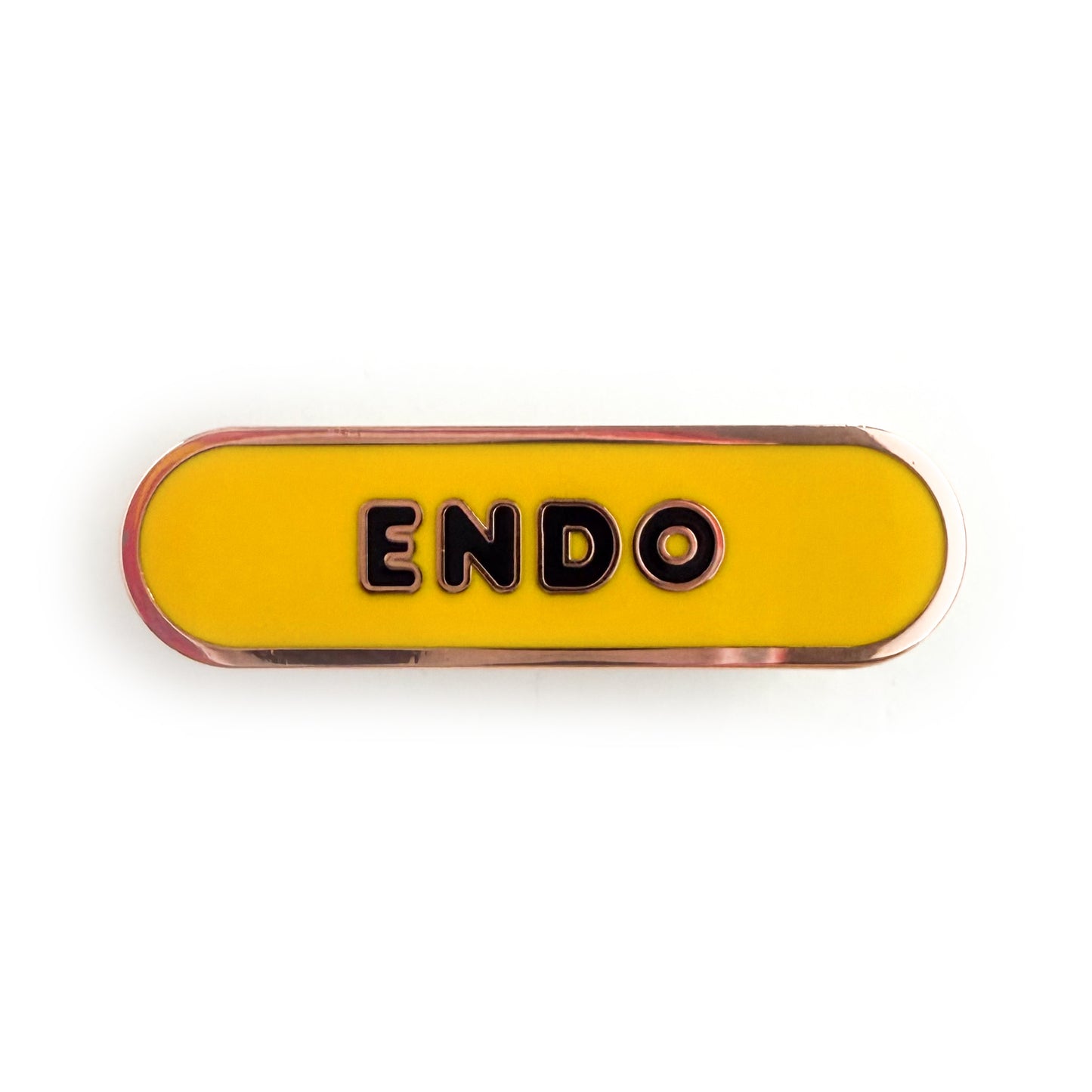A bandaid shaped pin with the text ENDO in bubble letters. The background is yellow and the text is black.