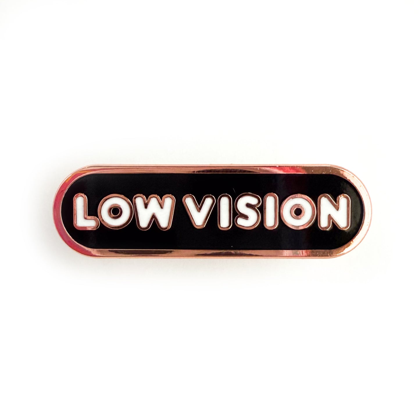 A bandaid shaped pin with the text LOW VISION  in bubble letters. The background is black and the text is white.