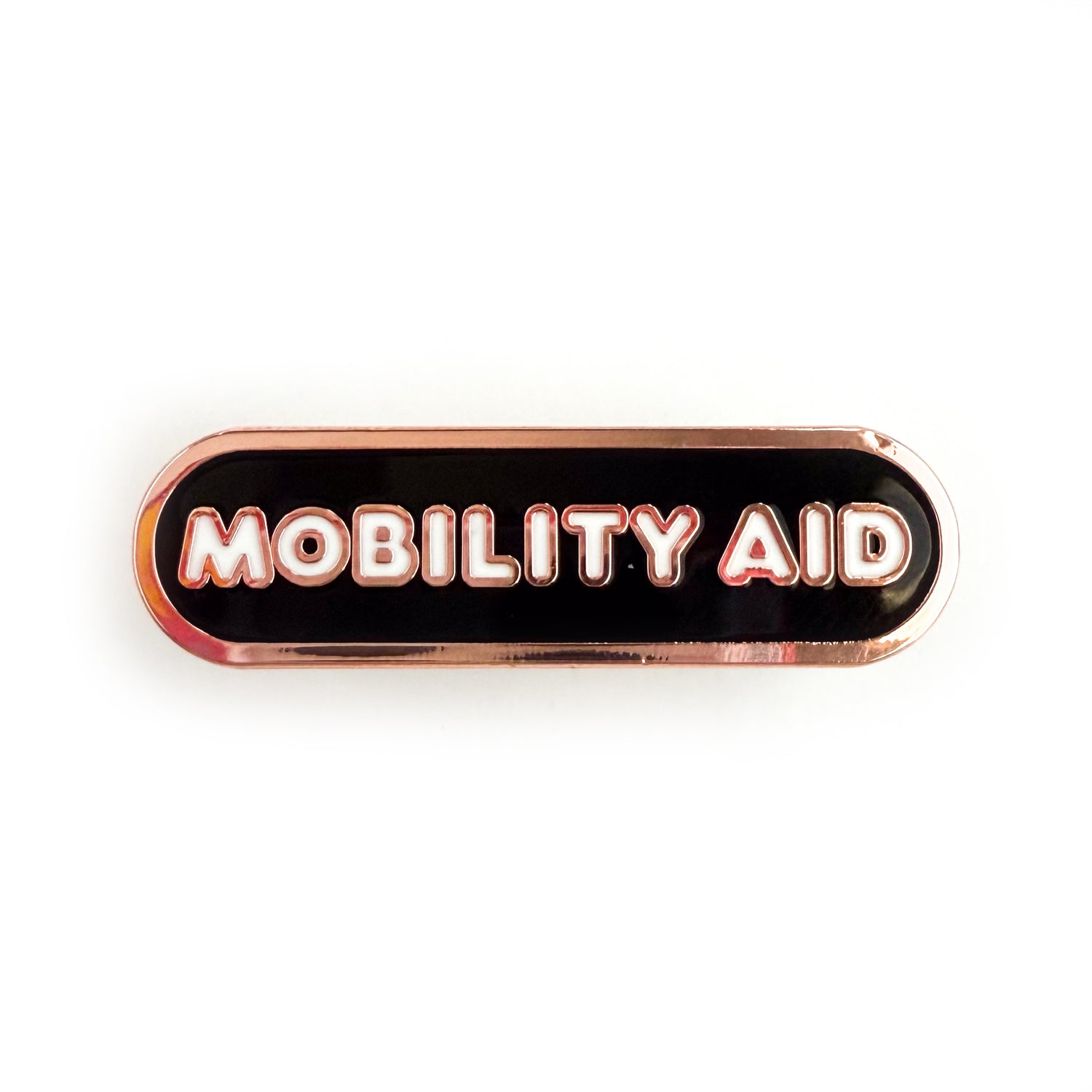 A bandaid shaped pin with the text MOBILITY AID in bubble letters. The background is black and the text is white.