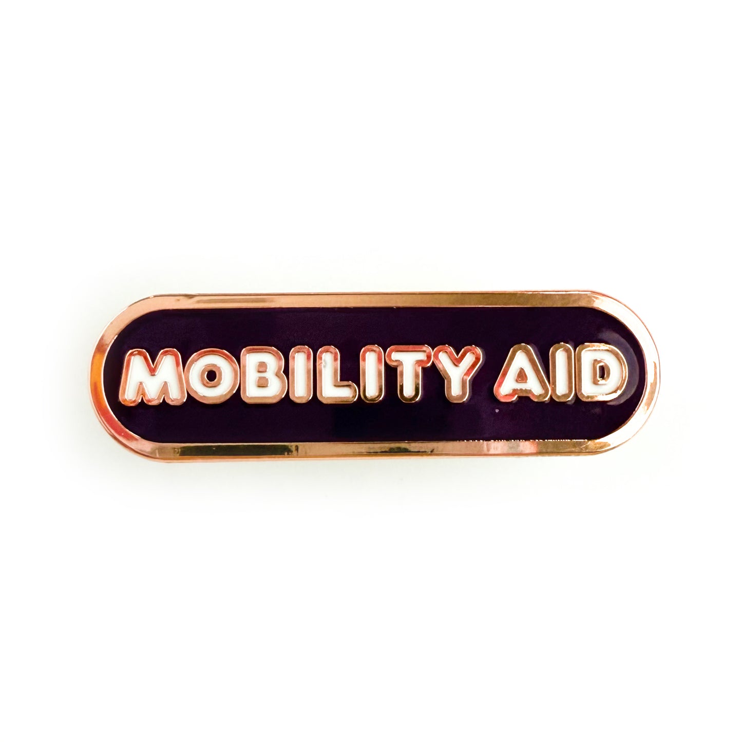A bandaid shaped pin with the text MOBILITY AID  in bubble letters. The background is dark purple and the text is white.