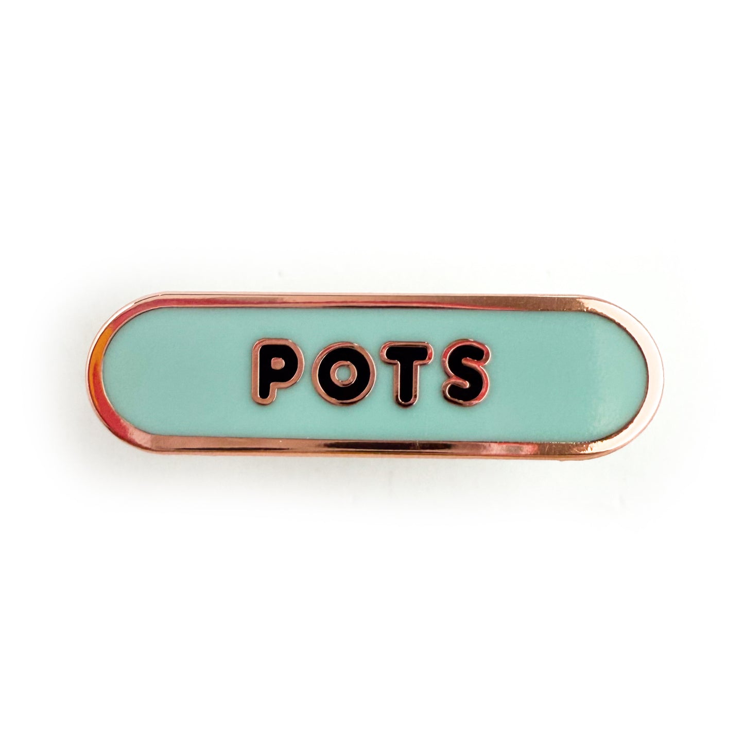 A bandaid shaped pin with the text POTS in bubble letters. The background is light blue and the text is black.