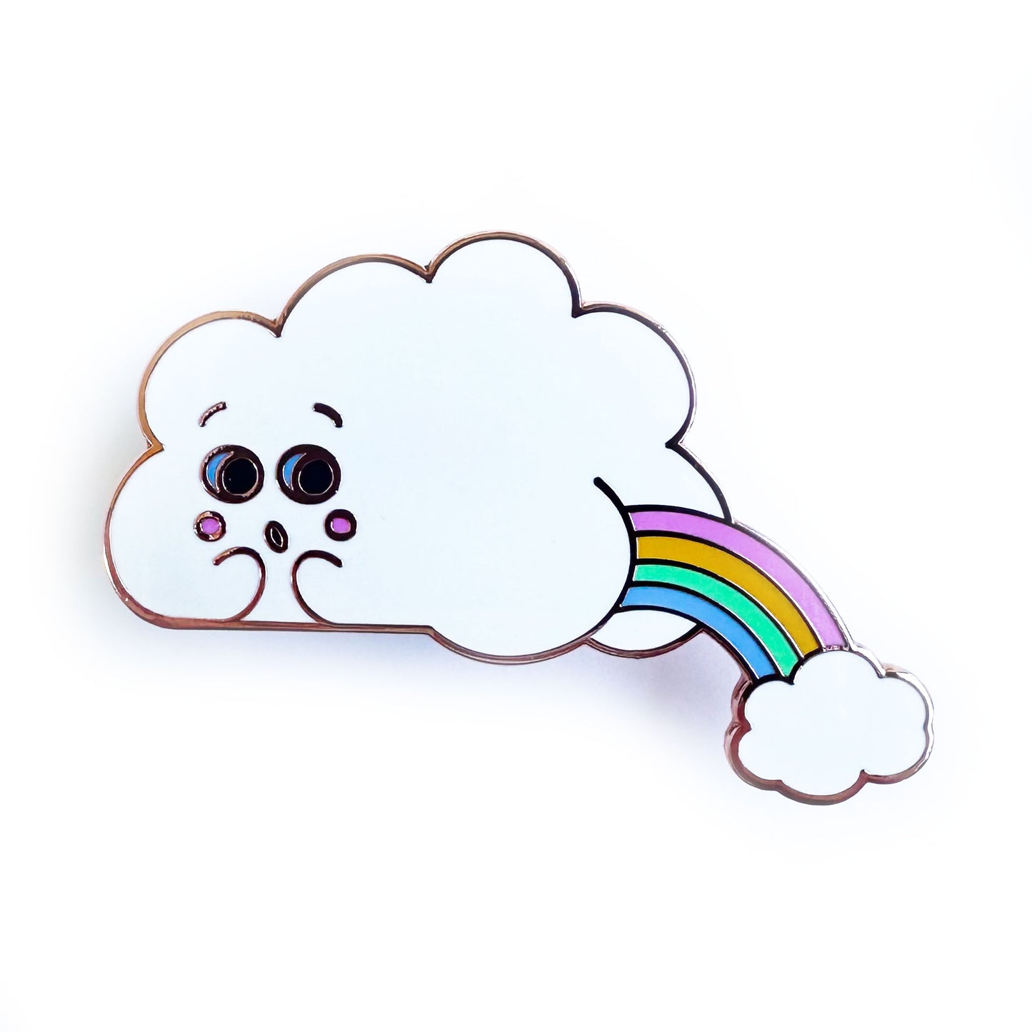 An enamel pin in the shape of a cloud with a face and a butt, there is a pastel rainbow arc coming out of the butt cheeks with another small cloud below it. The pin is on a white background.