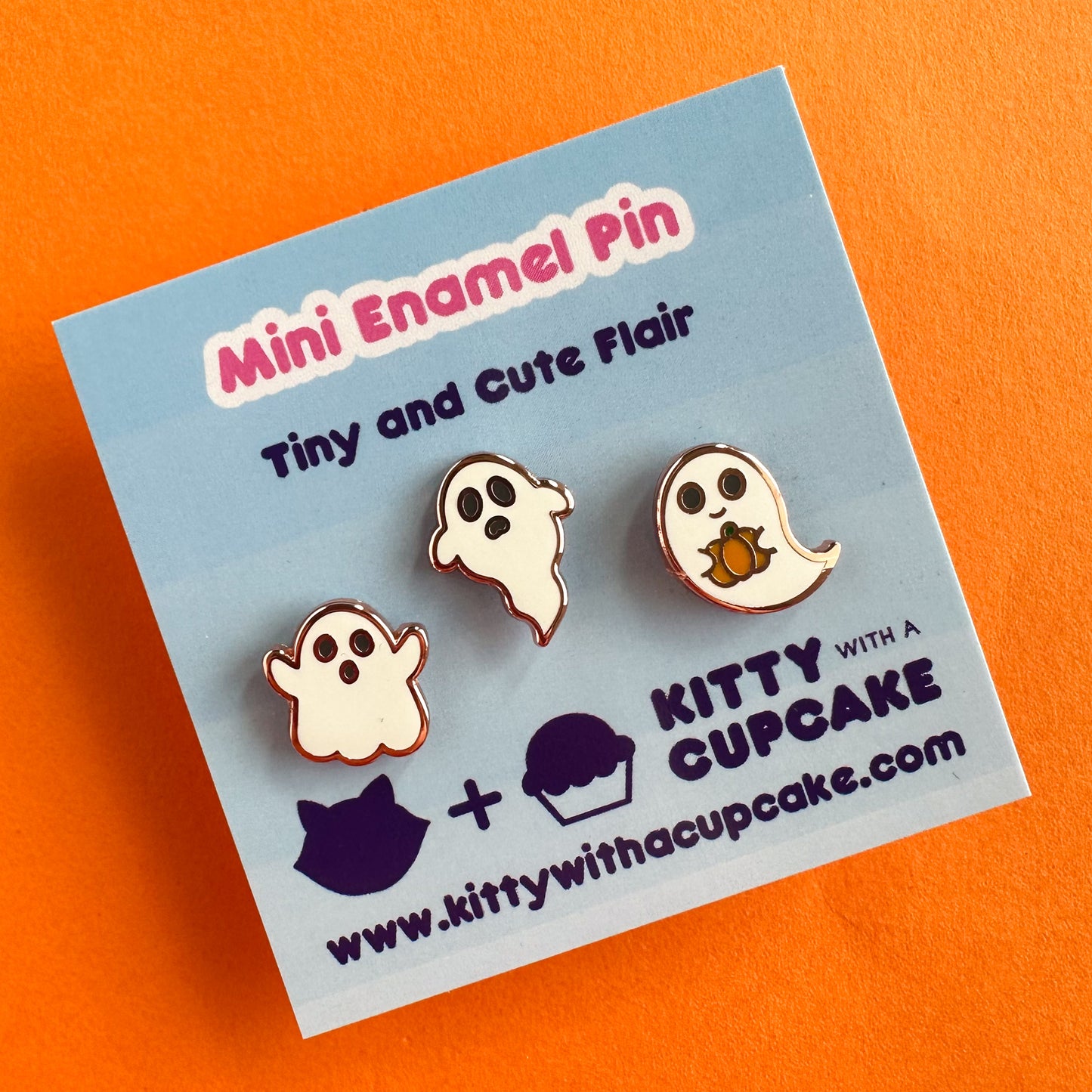 Three enamel pins packaged on a blue card that reads "Mini Enamel Pin - Tiny and Cute Flair" the pins are each shaped like a cute ghost.