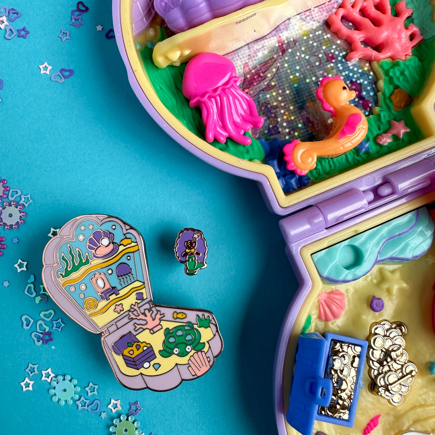 The mermaid pocket pin set is sitting next to a real Polly Pocket mermaid toy