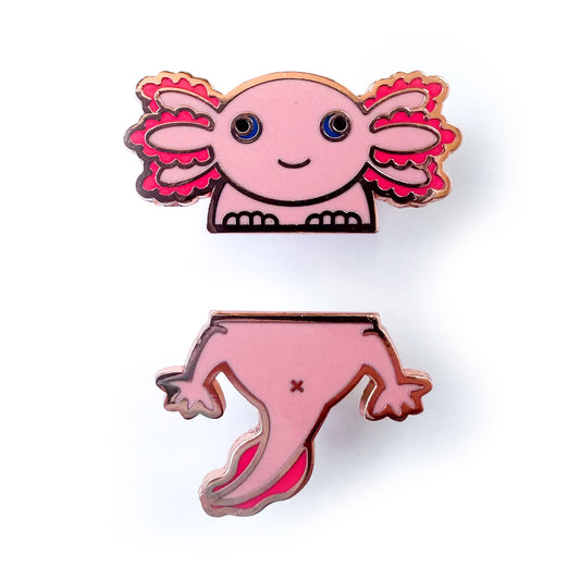 Two enamel pins of an axolotl split down the middle, one is the head and the other its the bottom and tail. The axolotl is pink with blue eyes and hot pink gills.
