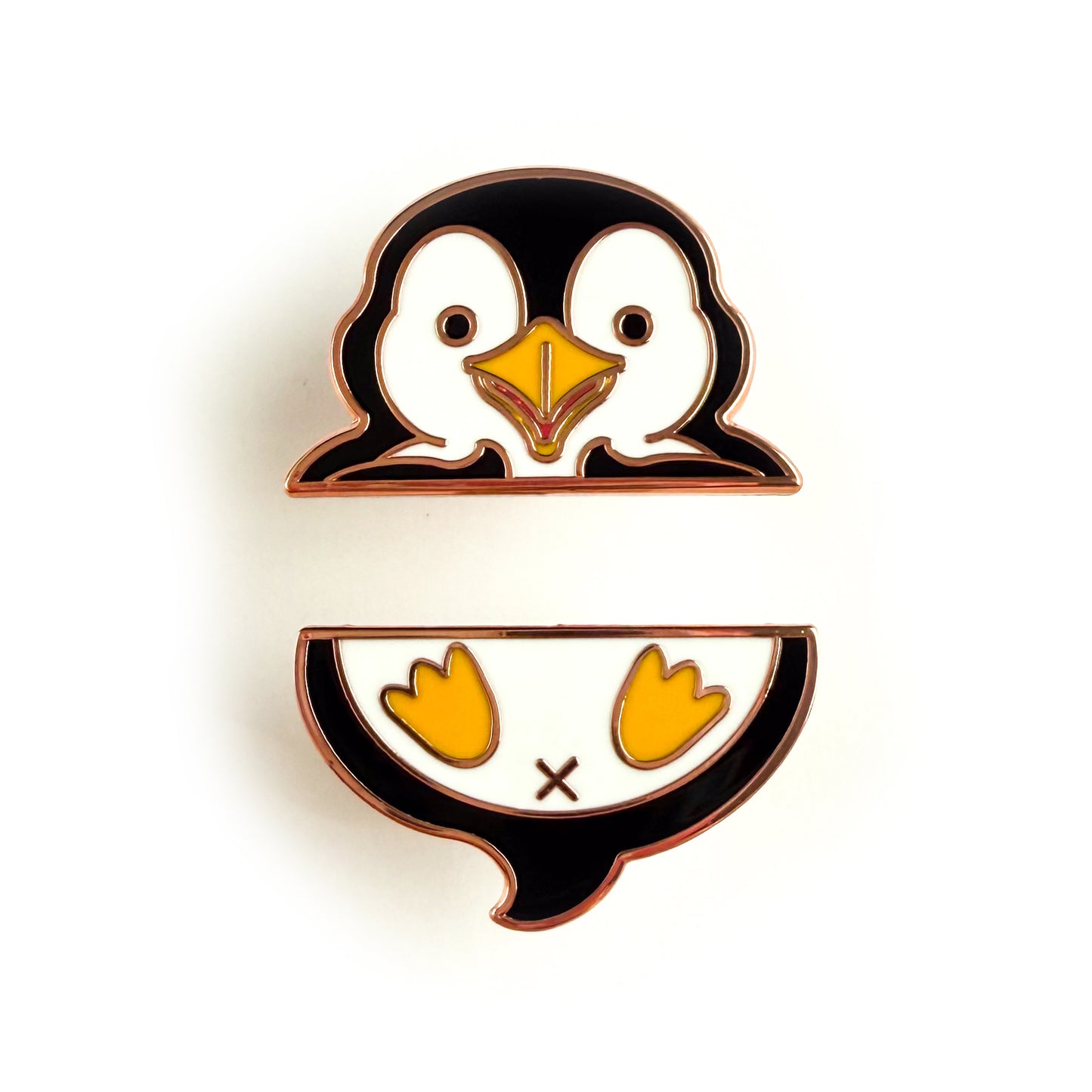 A two piece pin set that comes together to form a penguin. The top pin is the penguin’s wings and head. The bottom pin is the penguin’s butt, tail, and feet.
