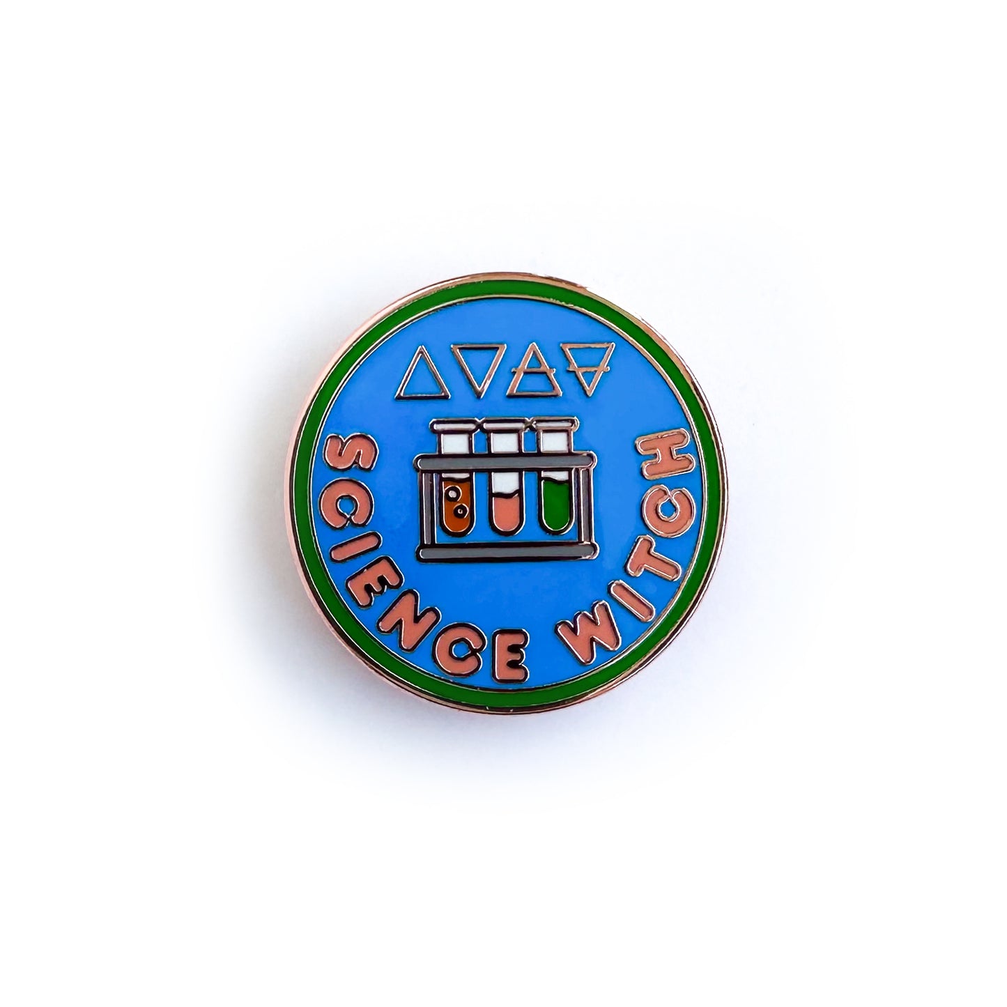 An enamel pin shaped like a circular merit badge with the words "Science Witch" and a rack of test tubes on it. The alchemical symbols for the four elements are above the test tubes.
