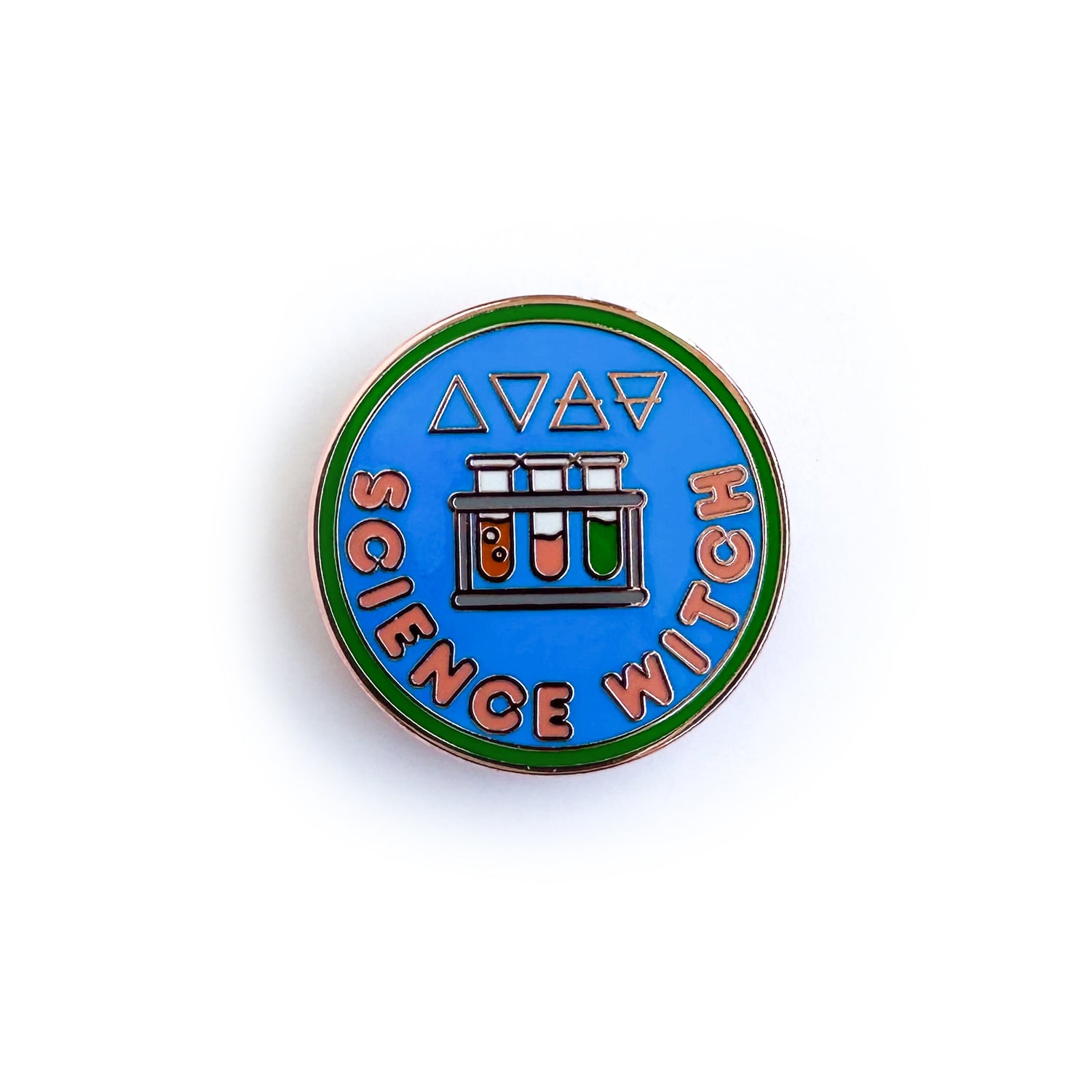 An enamel pin shaped like a circular merit badge with the words "Science Witch" and a rack of test tubes on it. The alchemical symbols for the four elements are above the test tubes. 