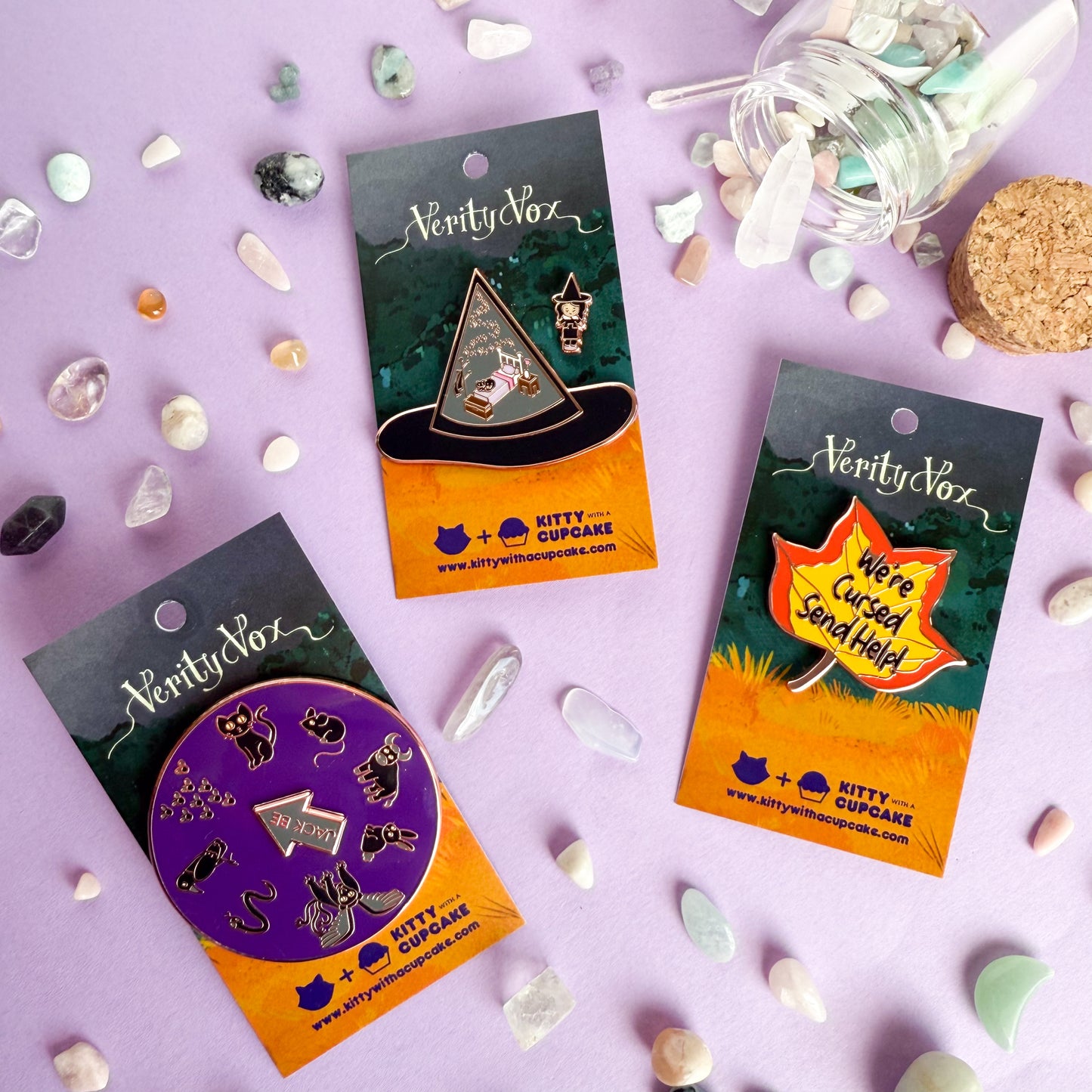 Verity vox pins packaged on cards with crystals around them spilled out of a bottle