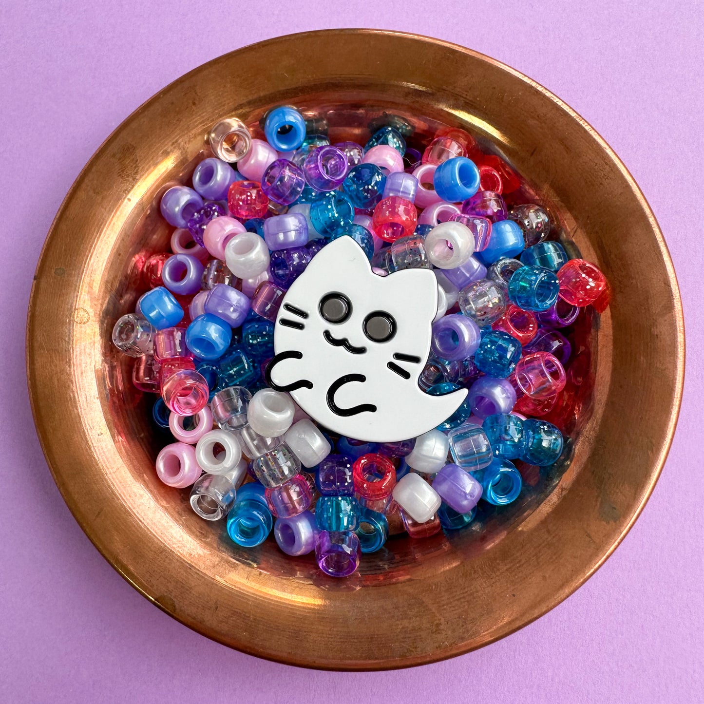Ghost kitty acetate hair clip in a copper bowl filled with blue, pink and purple pony beads.