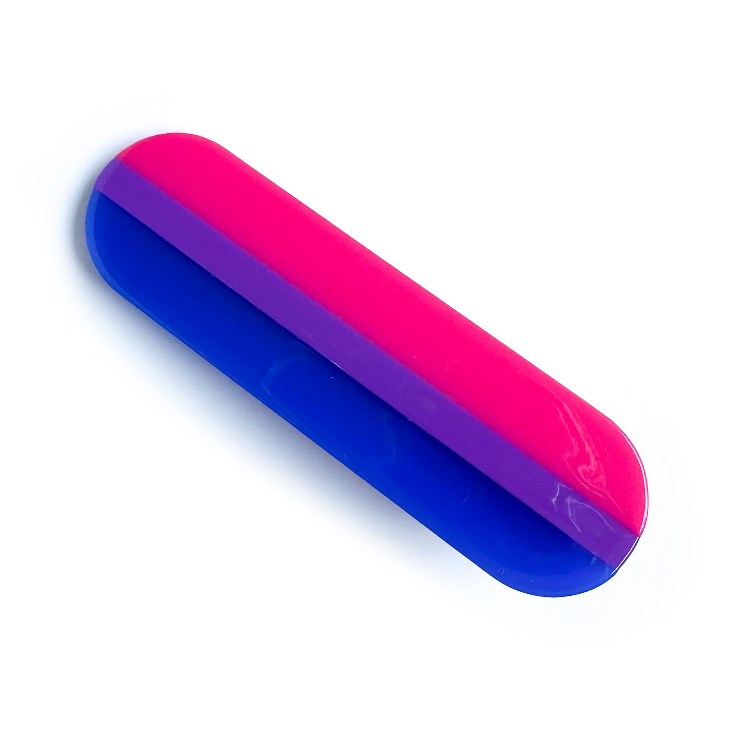 A capsule shaped hairclip in the colors of the bisexual pride flag.