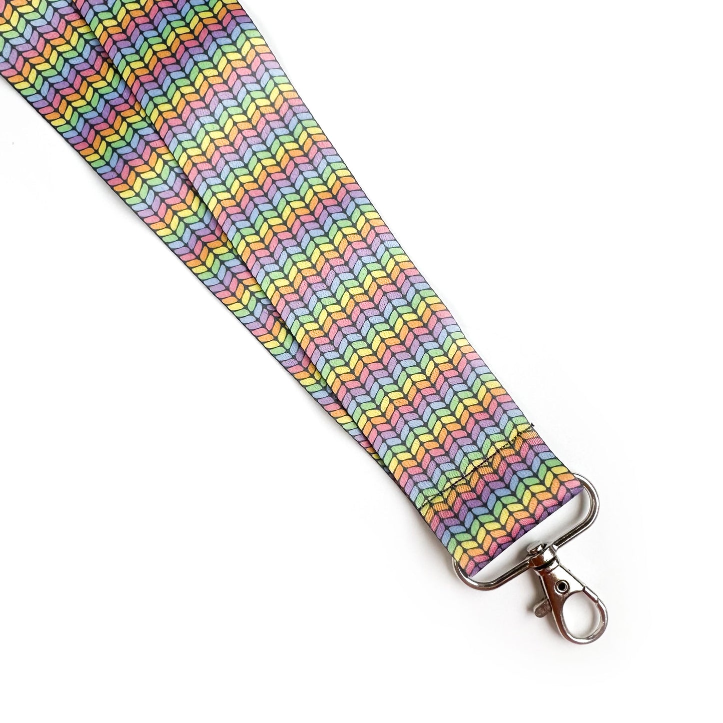A woven lanyard with a pastel rainbow stockinette stitch graphic printed on it with a silver metal lobster claw clasp at the bottom. 