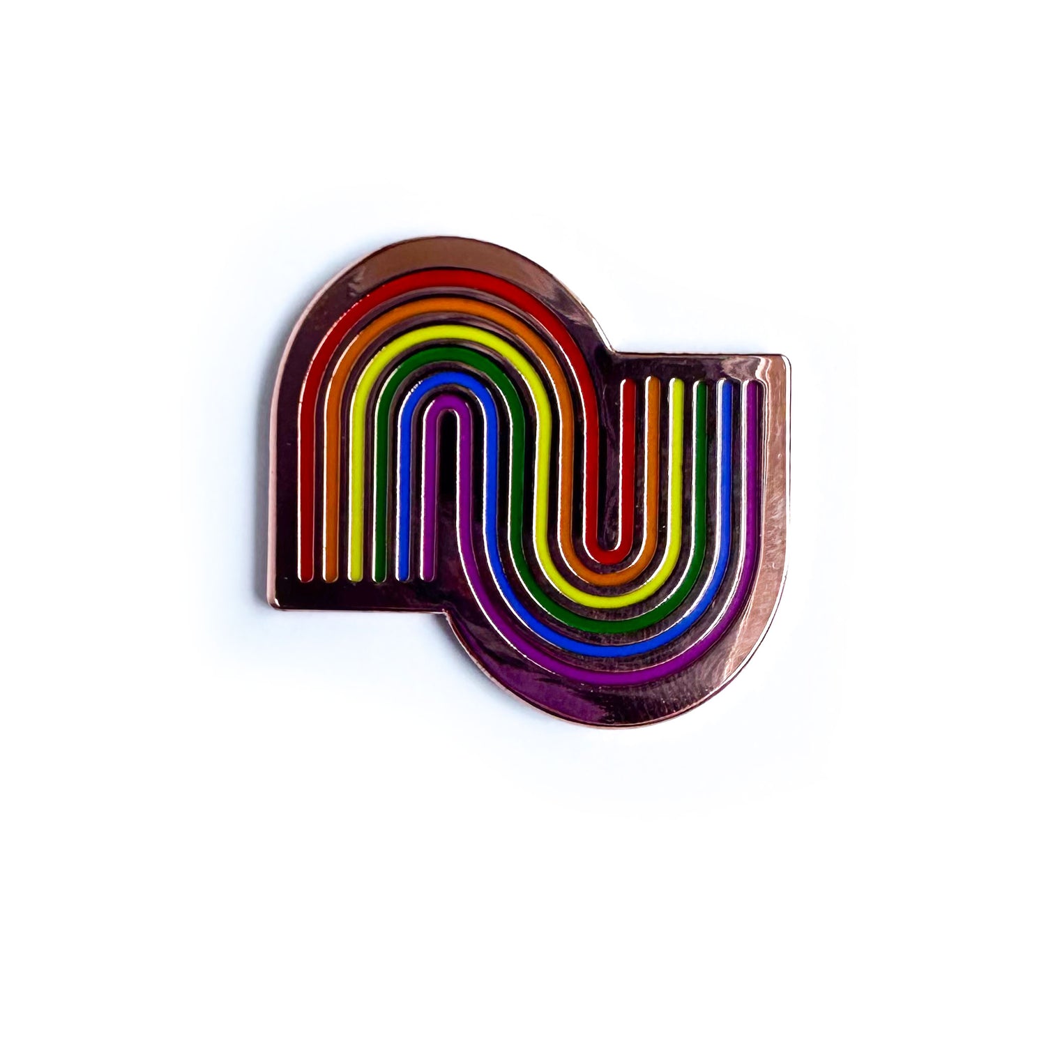 An enamel pin with one right side up rainbow intersecting with an upside down rainbow on copper metal.