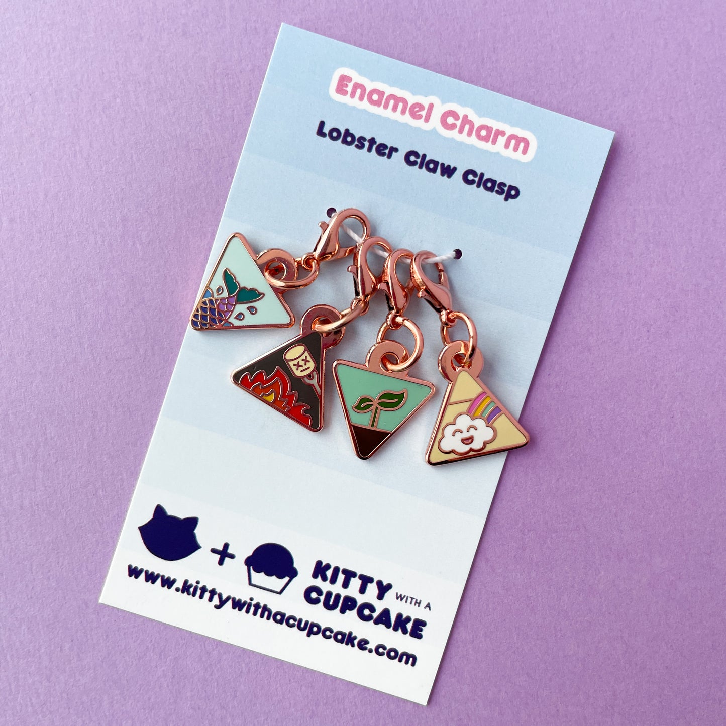 A set of four triangle charms on a blue card on a purple background.