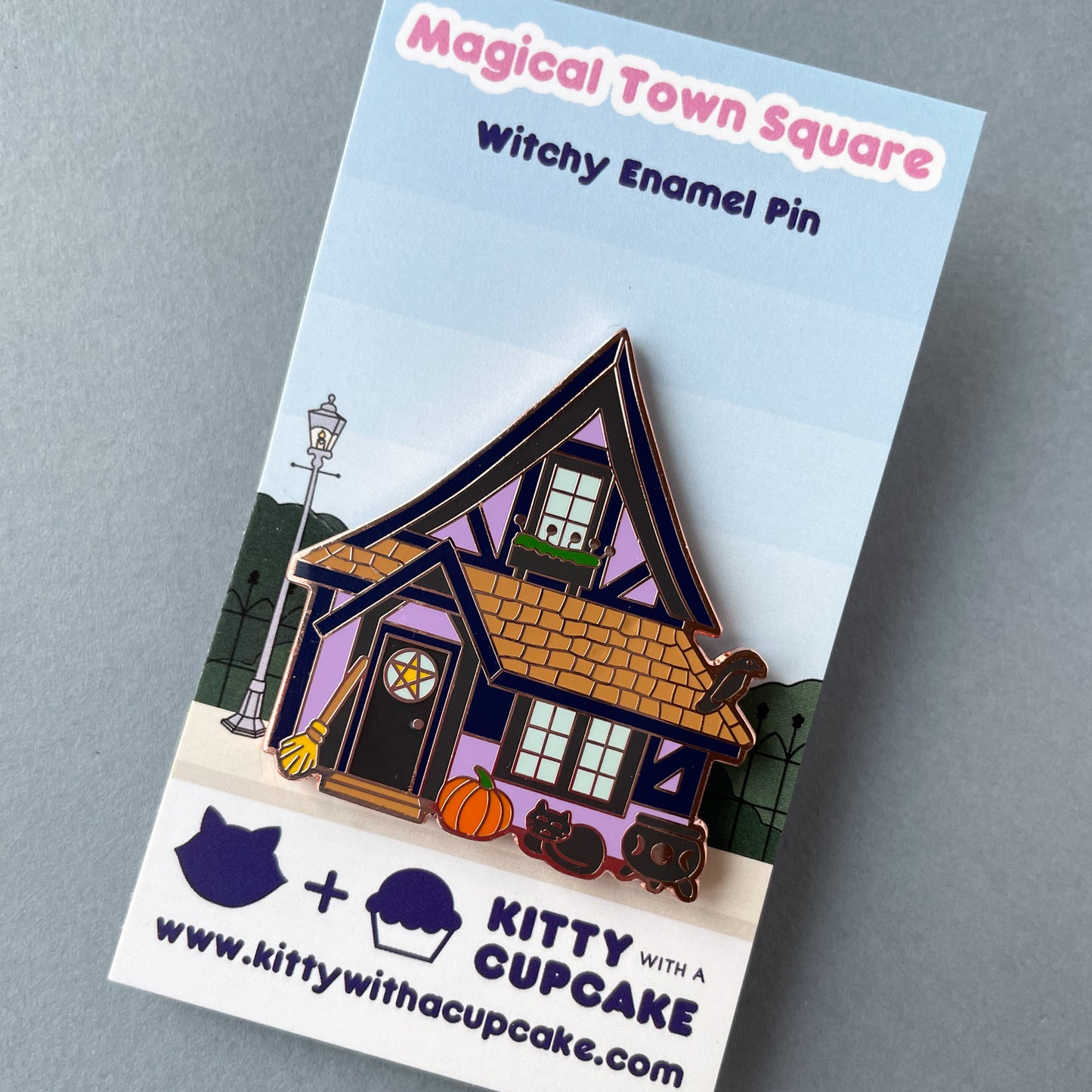 A purple house pin on a backing card that reads "Magical Town Square Witchy Enamel Pin".