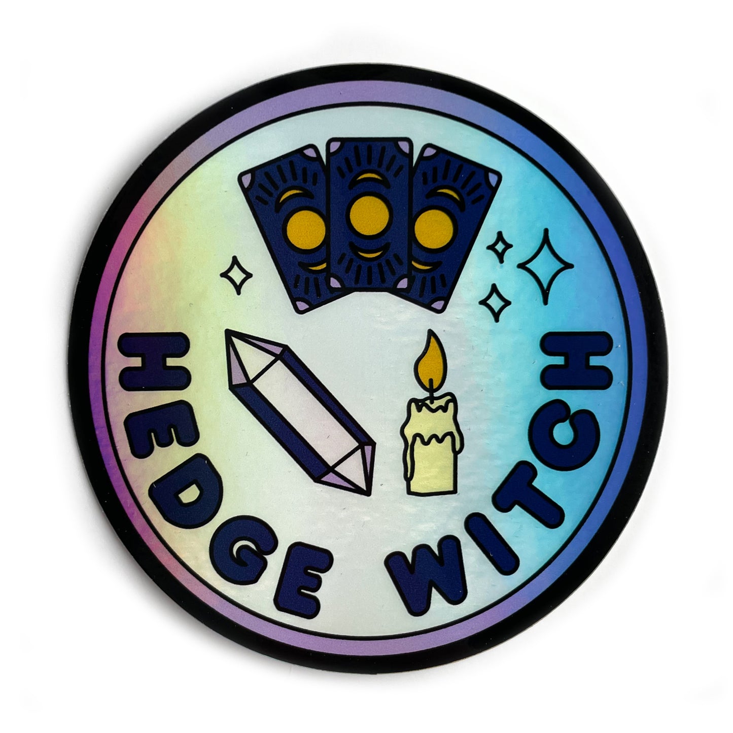A circular holographic sticker with a purple border and words that read "Hedge Witch". It has an amethyst crystal, a candle, and tarot cards depicted on it.