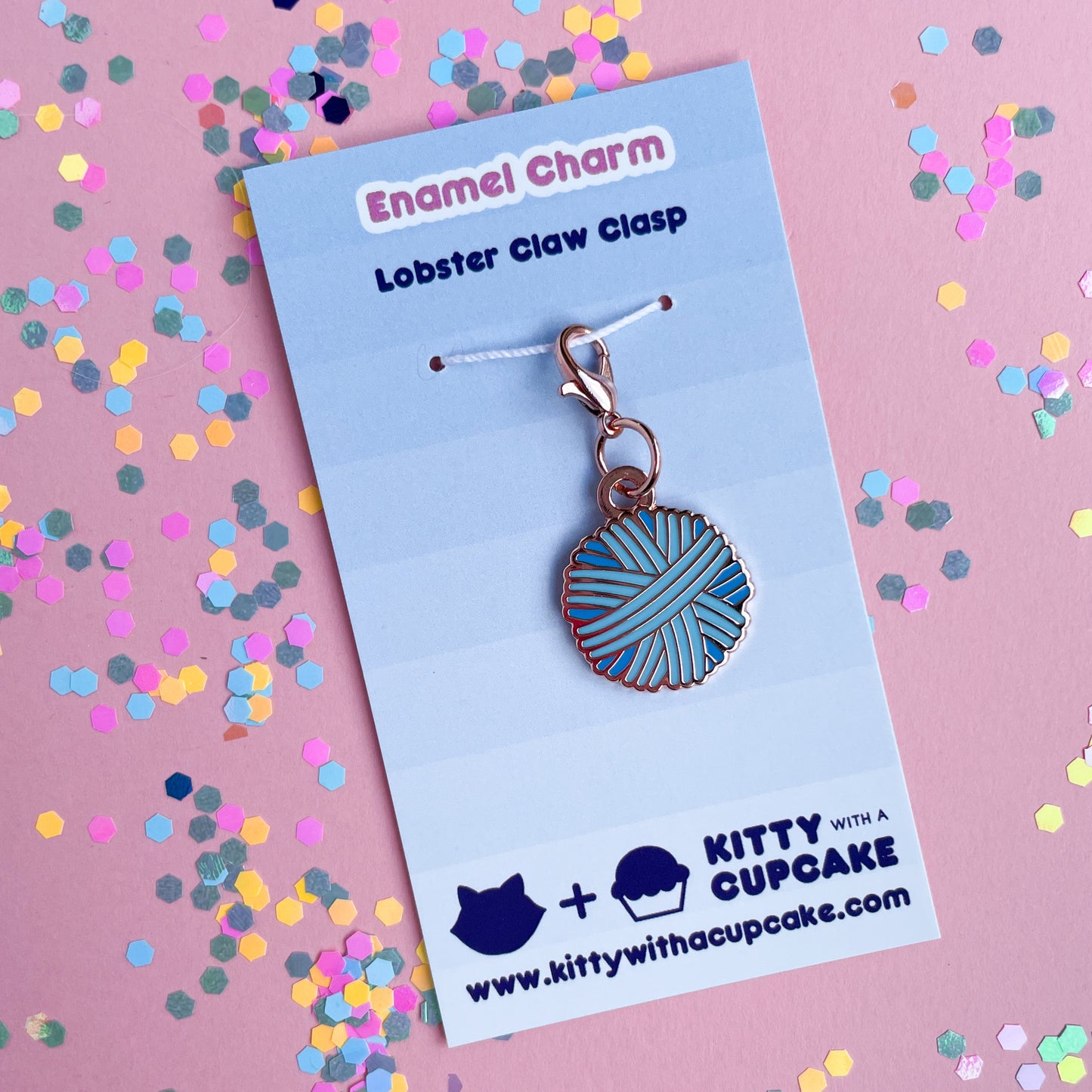 A blue yarn ball charm on a blue background.
