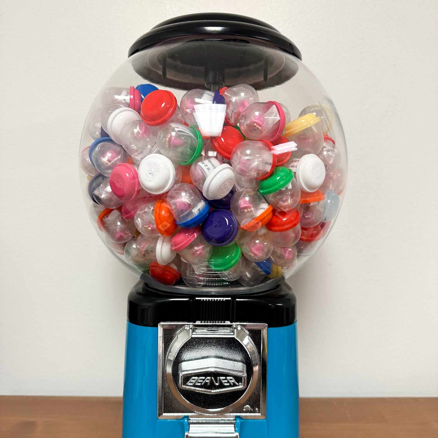 A gumball machine filled with multicolored capsules