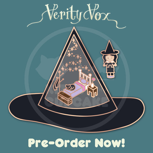A mockup of an enamel pin shaped like a hat with a miniature bedroom inside and a black cat sitting on the bed. There is a tiny witch shaped pin in a black dress and pointy hat next to the bigger hat. 'Verity Vox' branding is above the pin on a teal background.