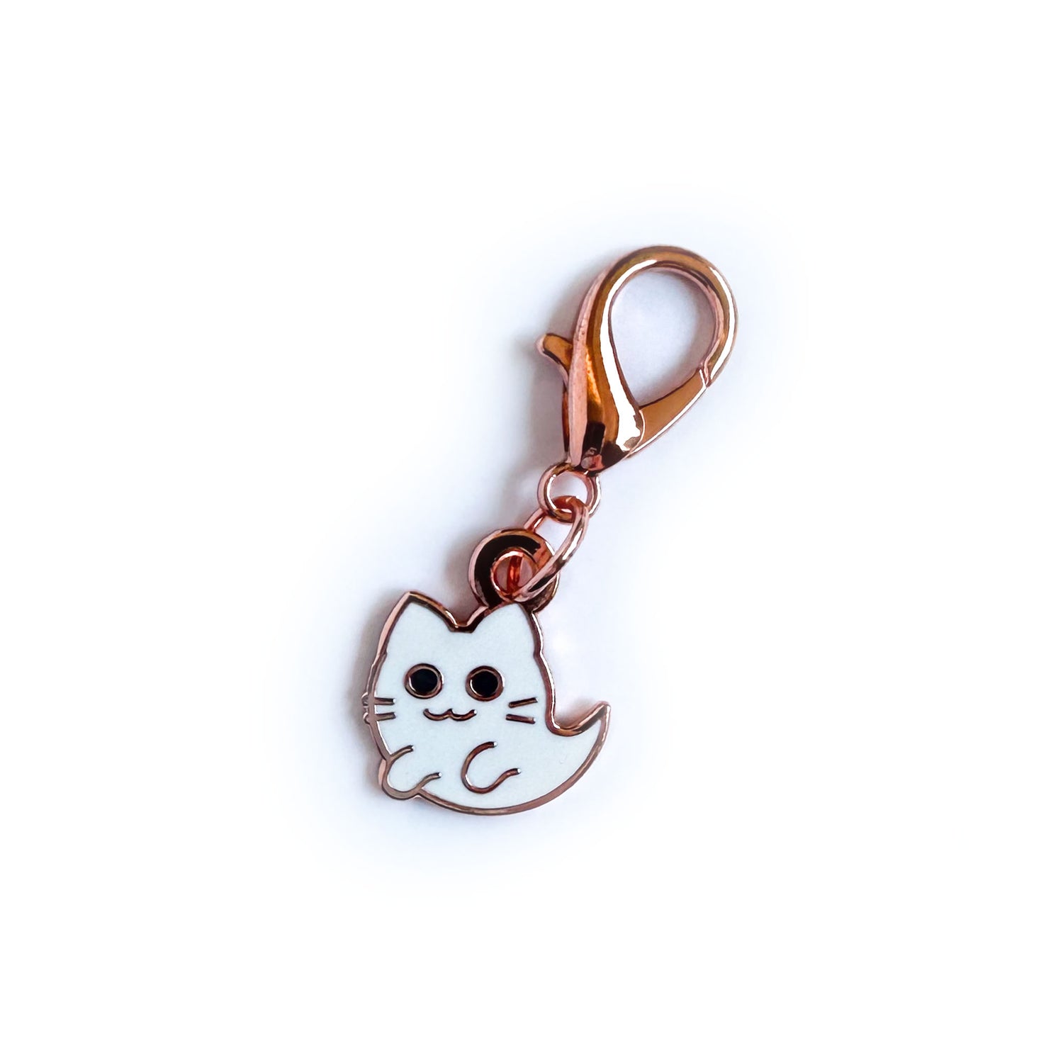 A lobster claw clasp charm of a ghost cat. The charm has copper colored metal and hard enamel details.