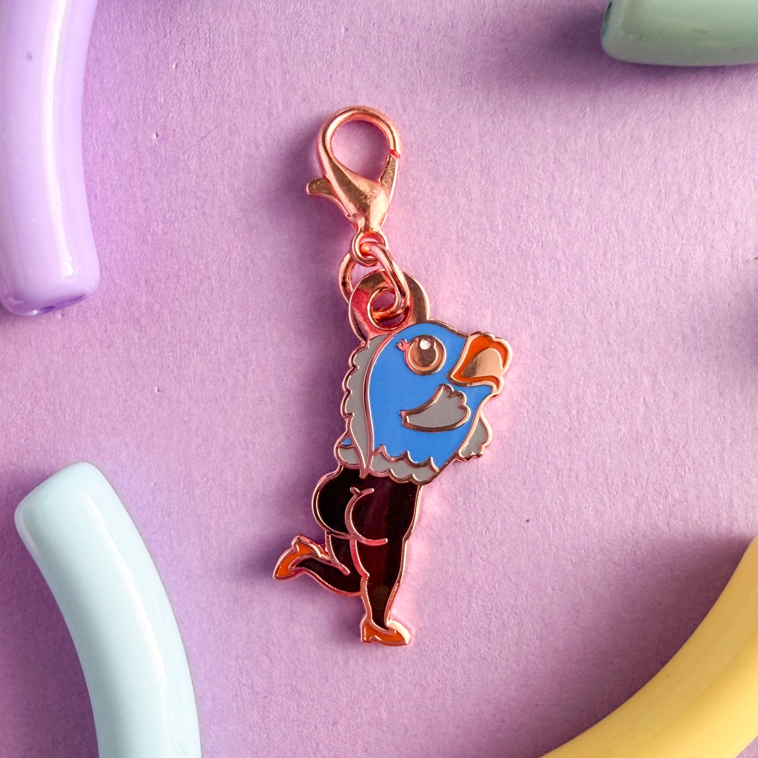 A lobster claw clasp charm shaped like a cartoon reverse mermaid, the top half is a fish and the bottom half is a naked lady with high heels. The fish is blue with a peach eye and coral lips, the lady legs are black with coral high heels. 