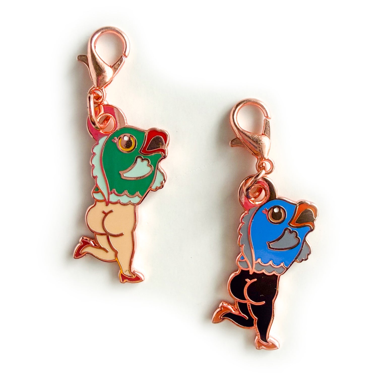 Two charms with lobster claw clasps shaped like reverse mermaids, fish on top and naked lady legs on the bottom with cheeks out and high heels on. One mermaid has a teal fish head with red lips and white legs and the other has a blue fish head with coral lips and black legs. 