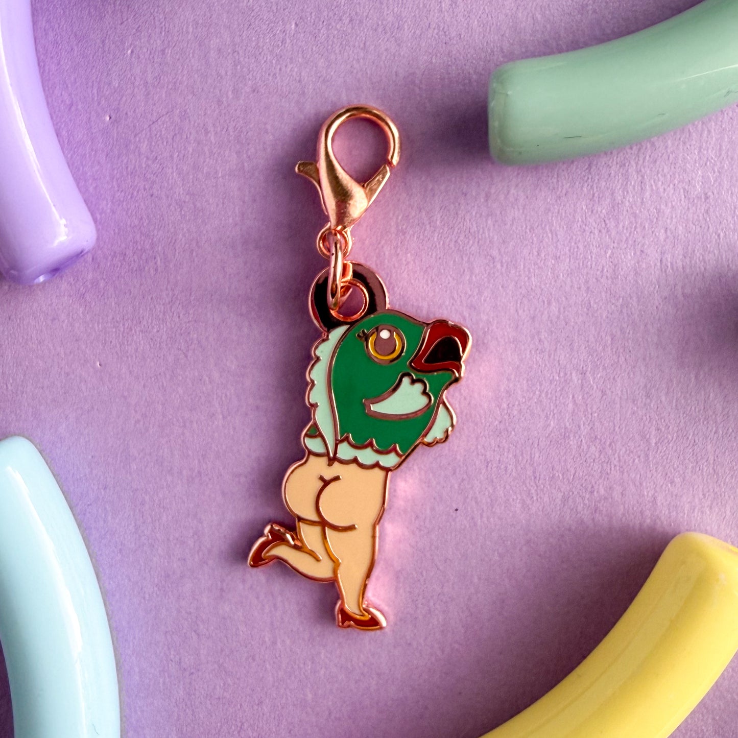 A lobster claw clasp charm shaped like a cartoon reverse mermaid, the top half is a fish and the bottom half is a naked lady with high heels. The fish is teal with a yellow eye and red lips, the lady legs are white with red high heels. 