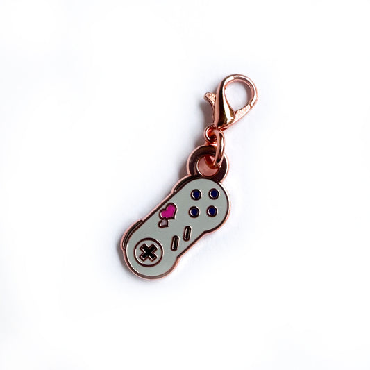 A lobster claw clasp charm shaped like a Super Nintendo controller with hearts on it.