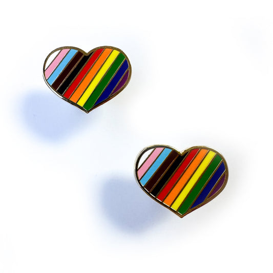 Two chunky heart post earrings with diagonal stripes in the colors of the progress pride flag. 