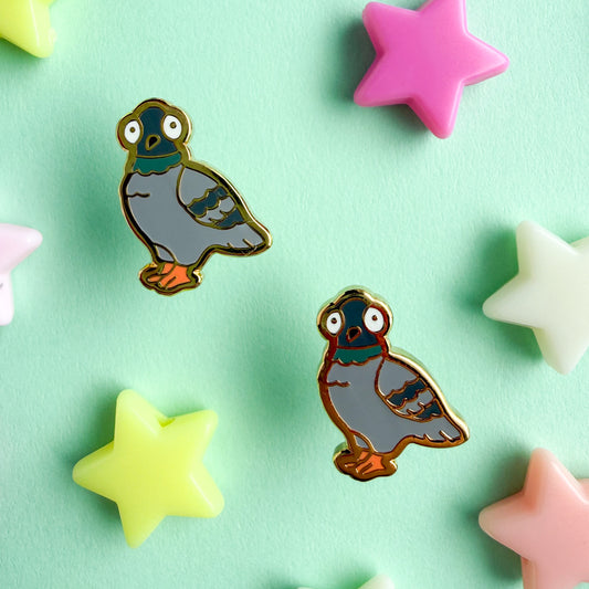 Post back earrings in the shape of pigeons on a green background with plastic star beads around them.