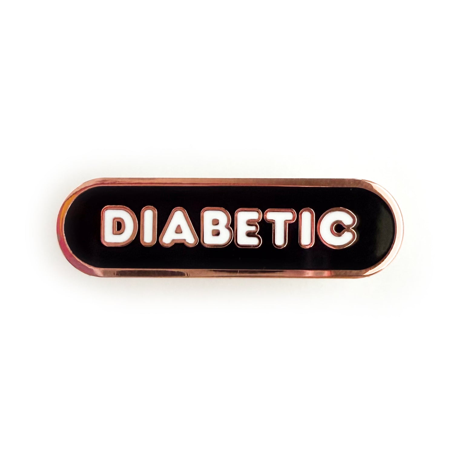 A bandaid shaped pin with the text DIABETIC in bubble letters. The background is black and the text is white.