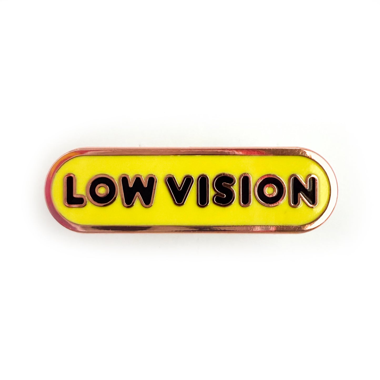 A bandaid shaped pin with the text LOW VISION  in bubble letters. The background is yellow and the text is black.