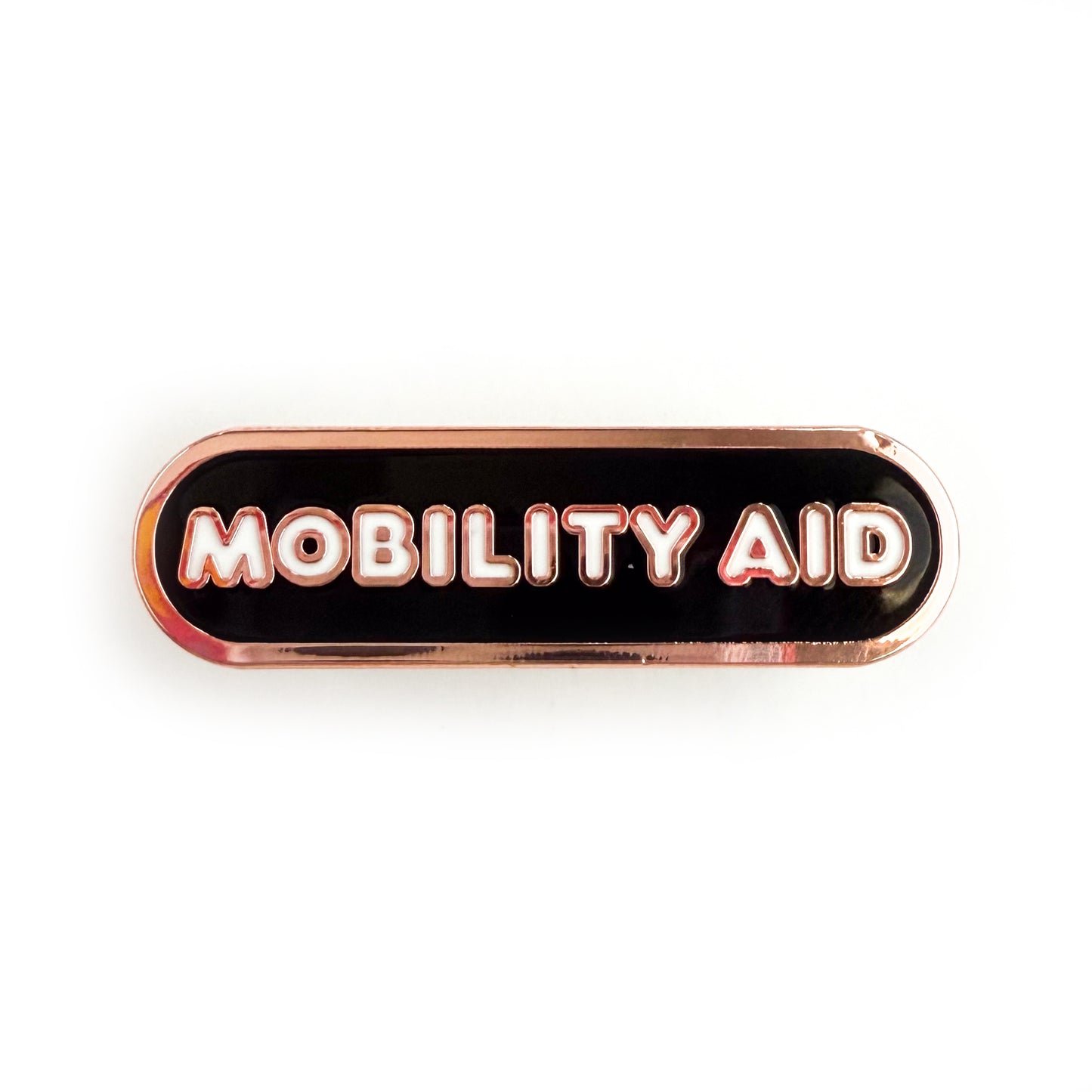 A bandaid shaped pin with the text MOBILITY AID in bubble letters. The background is black and the text is white.