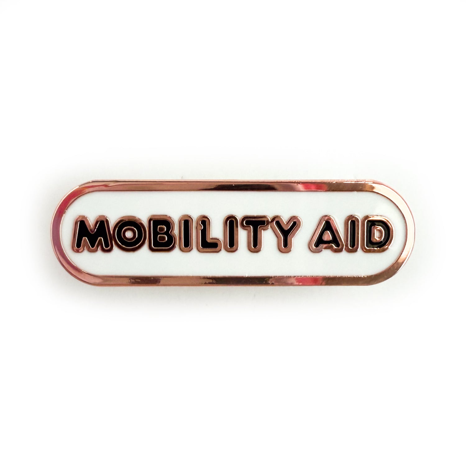 A bandaid shaped pin with the text MOBILITY AID  in bubble letters. The background is white and the text is black.