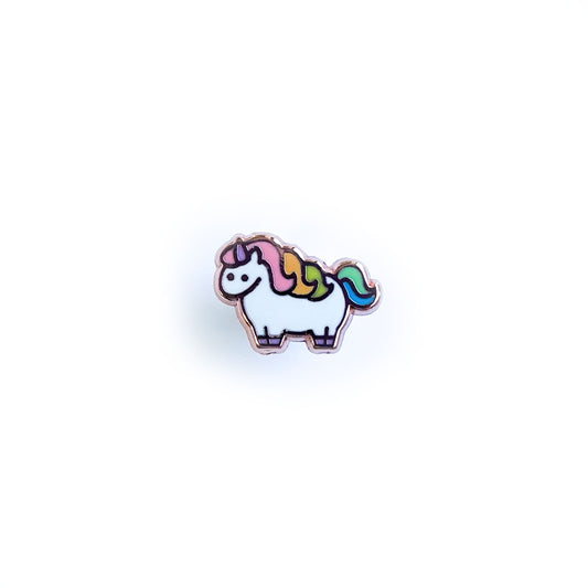 A mini enamel pin shaped like a cute illustration of a chubby unicorn with a pastel rainbow mane and tail. 