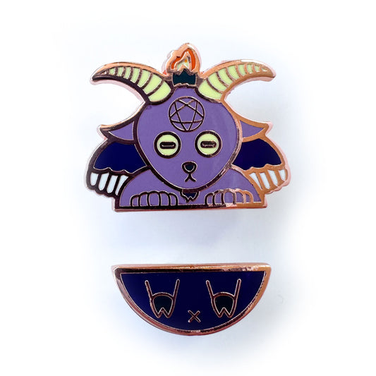 Two enamel pins representing Baphomet, one is the top part with the goat head, hands and wings, the other is the butt with hoof feet. 