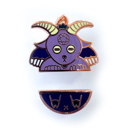 Two enamel pins representing Baphomet, one is the top part with the goat head, hands and wings, the other is the butt with hoof feet.