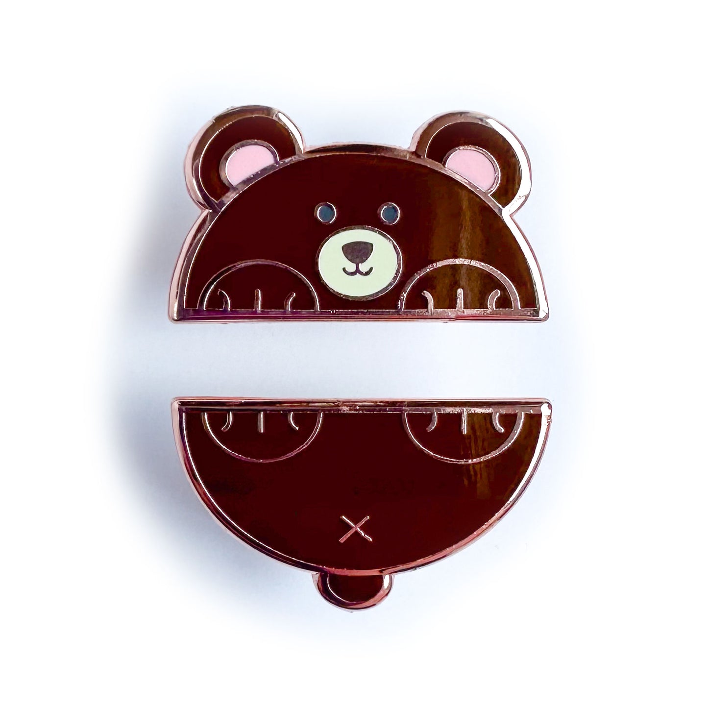 Two enamel pins that come together to form a bear cut in half horizontally. The top pin is the bear's head and front paws and the bottom is his tail and back paws. 