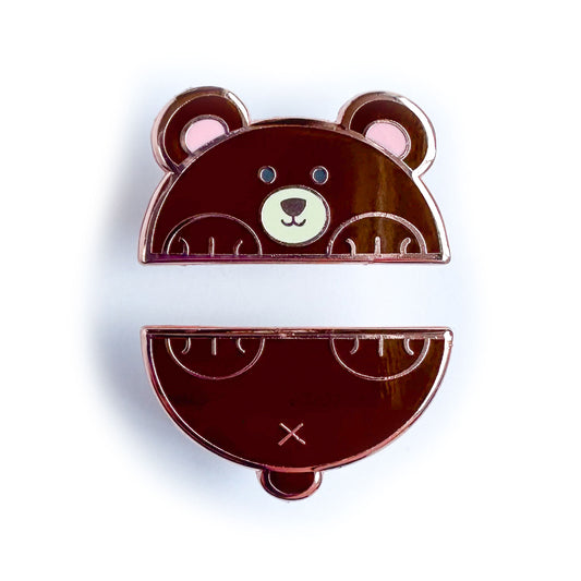 Two enamel pins that come together to form a bear cut in half horizontally. The top pin is the bear's head and front paws and the bottom is his tail and back paws.