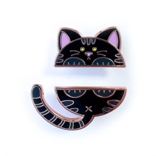 Two enamel pins that come together to form a cute round black cat. The top pin is the head and front paws and the bottom pin is the butt, tail and back paws. The cat has dark grey stripes and a pink nose.