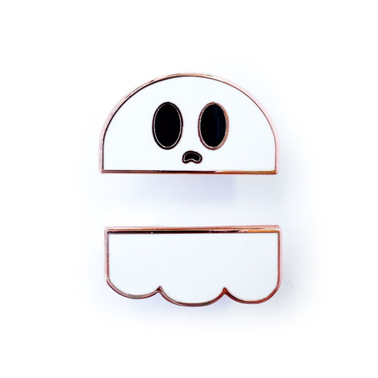 Two enamel pins that come together to form a ghost with big eyes and a mouth open in a ghostly whale.
