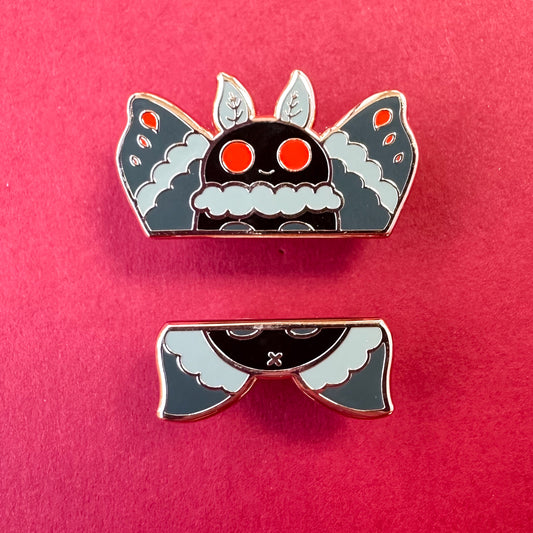 Two enamel pins that come together to form a cute illustration of Mothman. The pins are on a red background. 