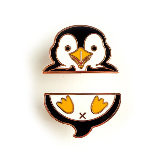 A two piece pin set that comes together to form a penguin. The top pin is the penguin’s wings and head. The bottom pin is the penguin’s butt, tail, and feet.