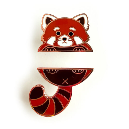 A two piece pin set that comes together to form a red panda. The top pin is the red panda’s top paws and head. The bottom pin is the red panda’s butt, stripped tail, and feet.