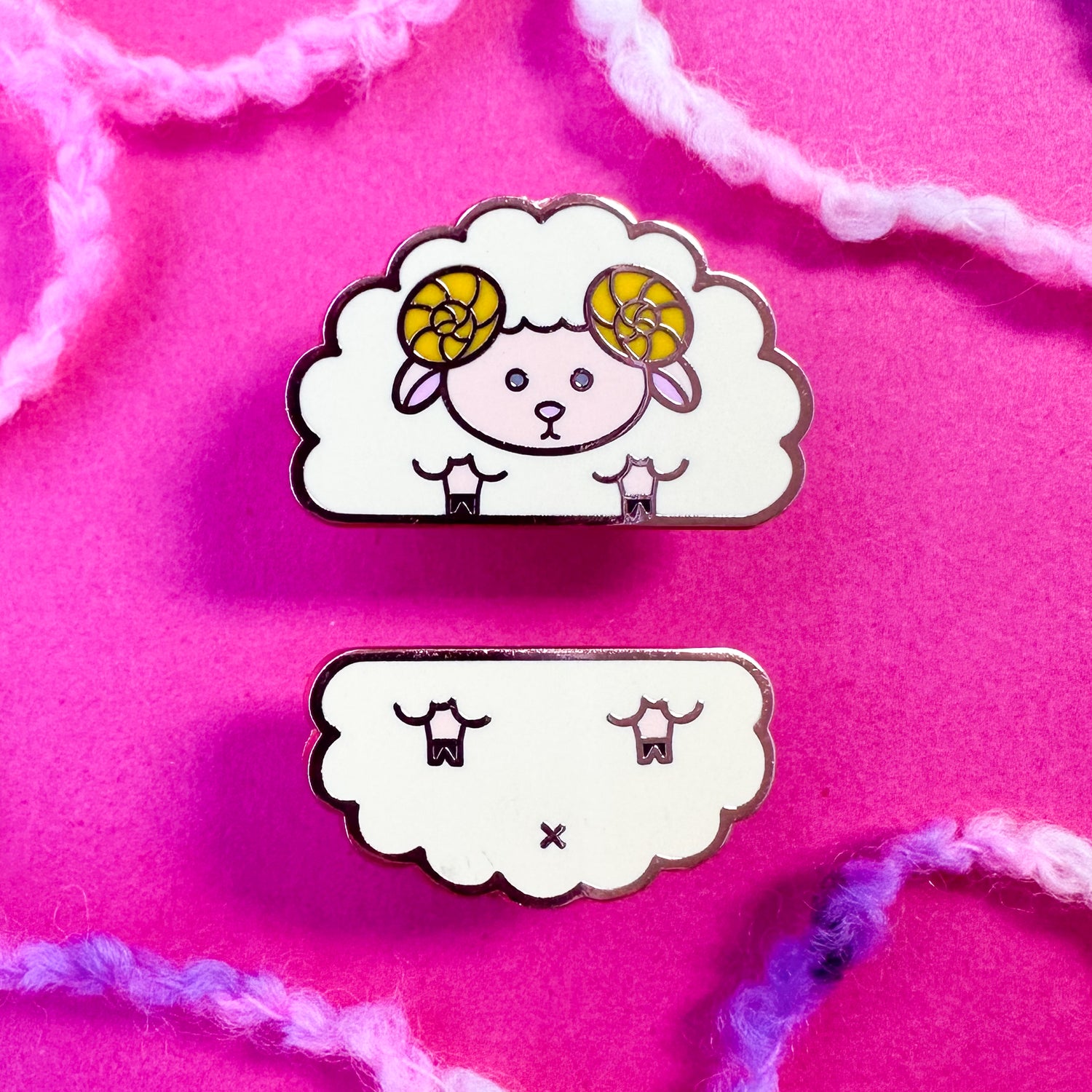 Two cute pins that come together to form a sheep. The pins are on a hot pink background with boucle yarn around it. 