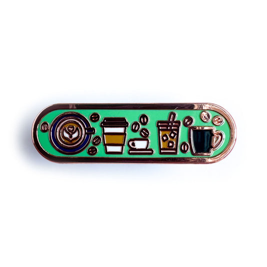 A capsule shaped enamel pin with illustrations of different coffee drinks on it including a latte with latte art, to-go hot drink, espresso cup, iced coffee and coffee mug. There are little coffee beans around these drinks.