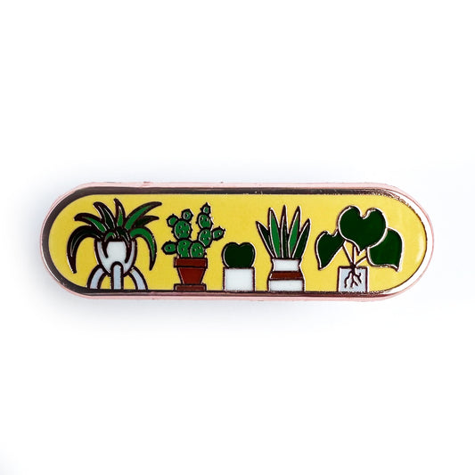 A capsule shaped pin with a yellow background and illustrations of cute houseplants on it.